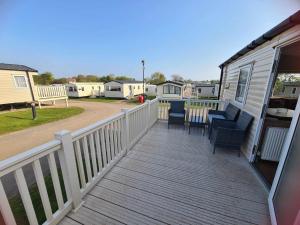 a deck with chairs and a table on a trailer at Happy Days Caravan Primrose Valley in Filey