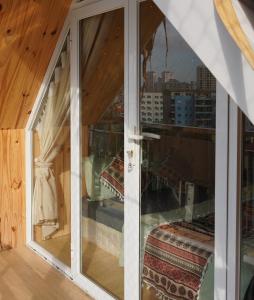 ハノイにあるKang's Home Cầu Giấyの市街の景色を望むガラスドア付きの客室です。