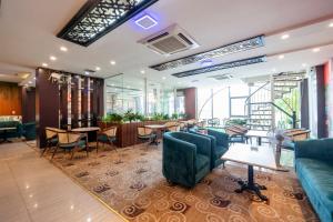 een lobby met tafels en stoelen en een restaurant bij Thien Phu Logia Hotel in Ho Chi Minh-stad