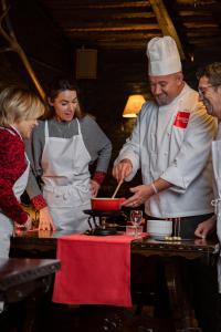 Ein Mann, der Essen in einer Küche mit einer Frau zubereitet. in der Unterkunft Edelweiss Manotel in Genf