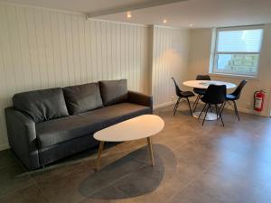 a living room with a couch and a table and chairs at Just Like Home Bed & Spa Porsgrunn in Porsgrunn