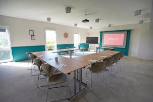 a classroom with tables and chairs and a projection screen at Appart’City Confort Montpellier Ovalie I in Montpellier