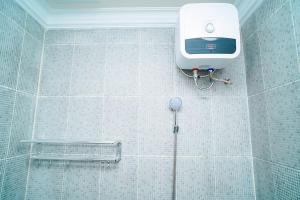 een betegelde badkamer met een douche bij Mess Rejeki Redpartner in Sampit