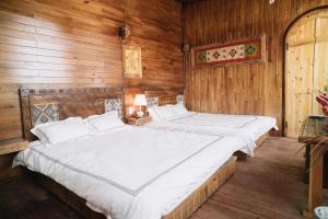 two beds in a room with wooden walls at Mộc Châu Harmony in Mộc Châu