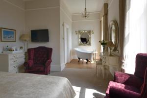 a bedroom with a bed and a tub and a sink at Wellwood Manor in Pitlochry