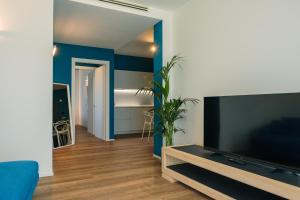 a living room with a large flat screen tv at Camoma Aparthotel - Boutique Hotel & Suites in Jesolo