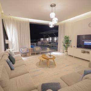 a living room with a couch and a tv at The Ocean Villa in Fujairah