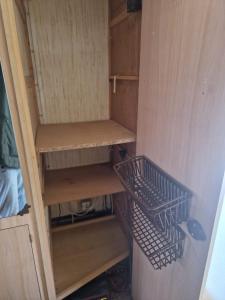LarochemillayにあるCamping La Foret du Morvan Caravan Joostの木製の棚と2つのバスケットが付いたクローゼット
