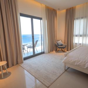 a bedroom with a bed and a view of the ocean at The Ocean Villa in Fujairah