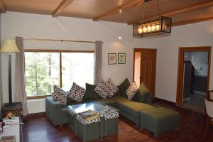 a living room with a couch and a table at Royal House in Nathia Gali