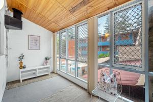 a living room with large windows and a bench at 26 Cottesloe Steps To Beach - Sleeps 2 - SUPERHOG REQUIRED in Perth