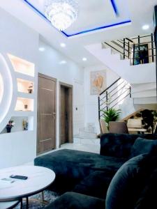 a living room with a couch and a staircase at Luxury House In Lekki Lagos in Lagos