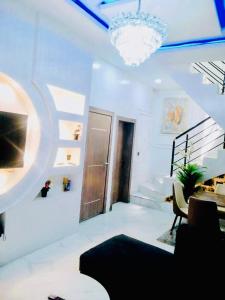 een witte woonkamer met een kroonluchter en een trap bij Luxury House In Lekki Lagos in Lagos