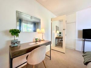 a room with a desk with a chair and a mirror at Mulgrave Harmony Guest House in Mulgrave