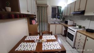 Διαμέρισμα στο Κέντρο της Χίου في خيوس: مطبخ مع طاولة مع زجاجات النبيذ عليه