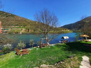 a view of a river with a bench and a swing at Apartmani Vila na Drini in Foča