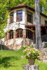 ein Steinhaus mit Blumen davor in der Unterkunft Kőszikla Vendégház a csendes pihenésre vágyóknak! in Kismaros