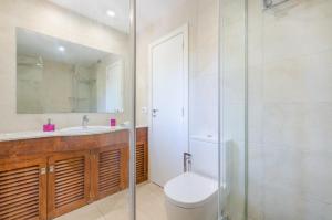 Un baño con inodoro, lavabo y espejo. en Cala Dor 14, en Cala d´Or 48 fotos más