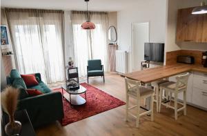 a living room with a green couch and a table at Appart charmant au cœur de la ville et des commodités in Saint-Ouen +9 photos
