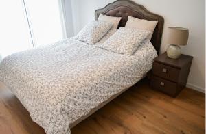 a bed with a white bedspread and pillows on it at Appart charmant au cœur de la ville et des commodités in Saint-Ouen