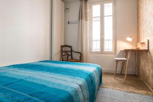 a bedroom with a blue bed and a window at Les Jardins suspendus in Angoulême
