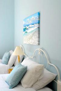 1 cama con almohadas y una foto de la playa en 6 Killean Place, en Campbeltown