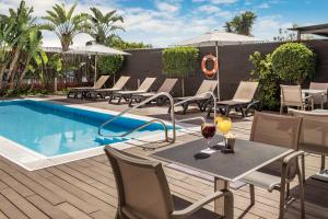 Eine Terrasse mit Tisch und Stühlen neben einem Pool in der Unterkunft Catalonia Hispalis in Sevilla + 21 Fotos