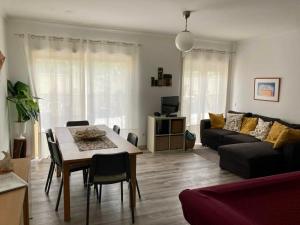 uma sala de estar com uma mesa e um sofá em Rocha’s Apartment REMODELADO! Na praia com terraço em Vila Nova de Gaia