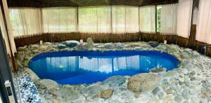 a large swimming pool with rocks and blue water at Mua Caves Ecolodge (Hang Mua) in Ninh Binh