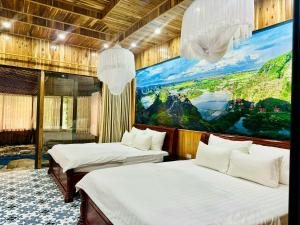 two beds in a room with a painting on the wall at Mua Caves Ecolodge (Hang Mua) in Ninh Binh