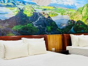 two beds in a room with a painting on the wall at Mua Caves Ecolodge (Hang Mua) in Ninh Binh