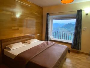 1 dormitorio con cama y ventana con vistas en Khushi Cottage en Mukteswar