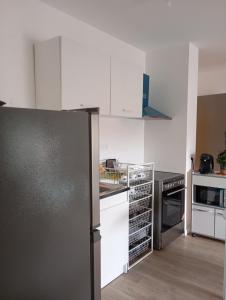 a kitchen with white cabinets and a black refrigerator at TheCALC Homes 2Bedroom+1Kitchen in Sartrouville +9 photos