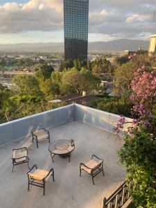 een patio met een tafel en stoelen op een dak bij #Universal in Los Angeles