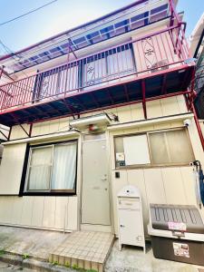 une maison avec un balcon au-dessus dans l'établissement 桜Home, à Tokyo