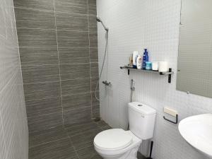 a bathroom with a toilet and a shower and a sink at Domaine d'Aba in Danang