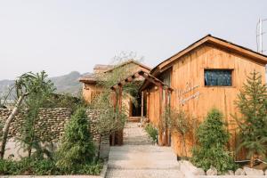 a wooden house with a pathway in front of it at Mộc Châu Harmony in Mộc Châu