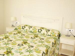 - une chambre dotée d'un lit avec un couvre-lit floral dans l'établissement Apartamentos Esmeralda Suites Unitursa, à Calp