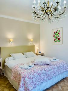 a bedroom with a large bed with a chandelier at La naronne in Bandol