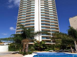 a tall building with a swimming pool in front of a building at Apartamentos Esmeralda Suites Unitursa in Calpe