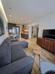 sala de estar con sofá azul y cocina en Lap Home Kavala, en Kavala