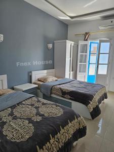 two beds in a room with a guest house at Fnex House in Dahab