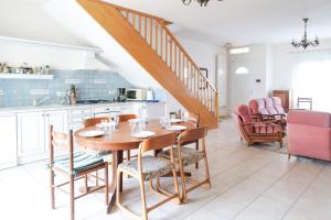 eine Küche und ein Esszimmer mit einem Holztisch und Stühlen in der Unterkunft Spacieuse maison avec extérieur quartier Arago Les Sables 7 personnes in Les Sables-dʼOlonne
