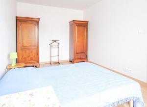 ein Schlafzimmer mit einem Bett und einem Holzschrank in der Unterkunft Spacieuse maison avec extérieur quartier Arago Les Sables 7 personnes in Les Sables-dʼOlonne