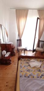 1 Schlafzimmer mit einem Bett, 2 Stühlen und einem Fenster in der Unterkunft Etno smeštaj Stojadinović in Svrljig
