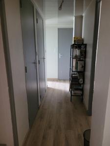 um quarto vazio com um corredor com uma porta e pisos de madeira em Appartement Le Pontet em Avignon