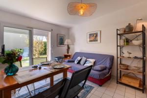 a living room with a blue couch and a table at Port et plages à deux pas in Sarzeau