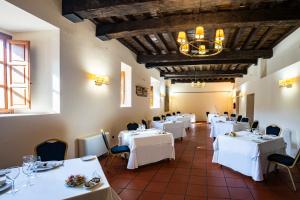 エルバスにあるHospedería Valle del Ambrozの白いテーブルと椅子、シャンデリアのあるレストラン