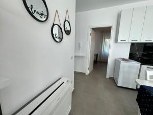 a kitchen with three clocks on the wall at SoleMar Suites in Vlorë