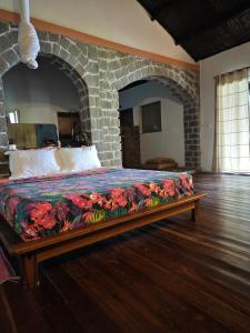 a bed in a room with a stone wall at blue fenix in Mahavelo